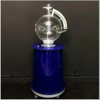 Full lottery machine with transparent ball chamber and LED ball rail on a blue rolling pedestal against a dark backdrop