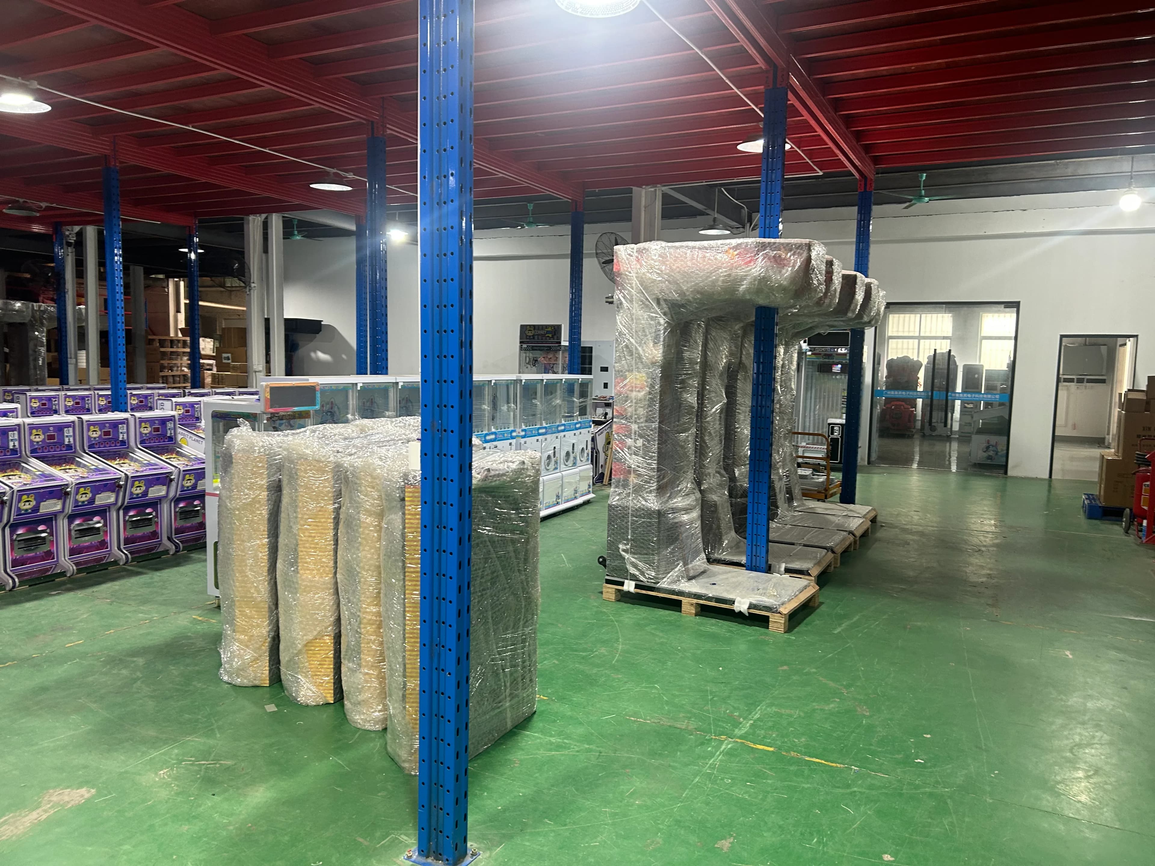 Jisun factory floor with finished prize machines and wrapped arcade cabinets in July 2026
