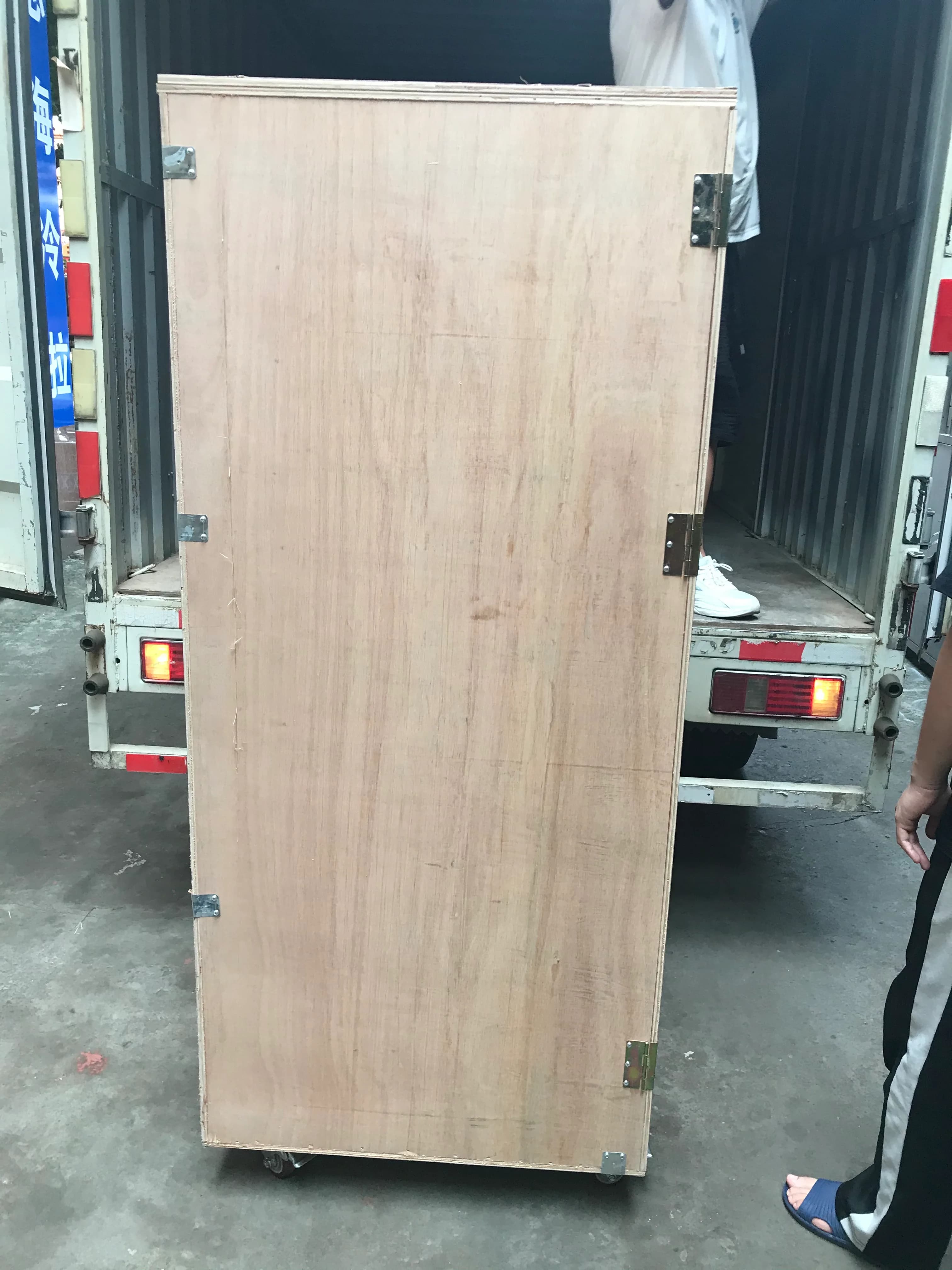 Two tall wooden lottery machine crates staged on a truck bed for transport