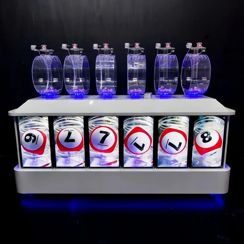 Front view of a 6-chamber lottery ball machine with six clear drums and a numbered ball display cabinet under blue LED light