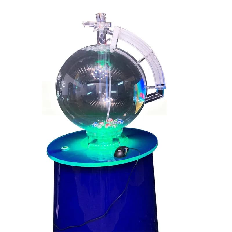 Front view of a fast draw lottery machine with clear sphere, blue pedestal, green LED base light and numbered balls
